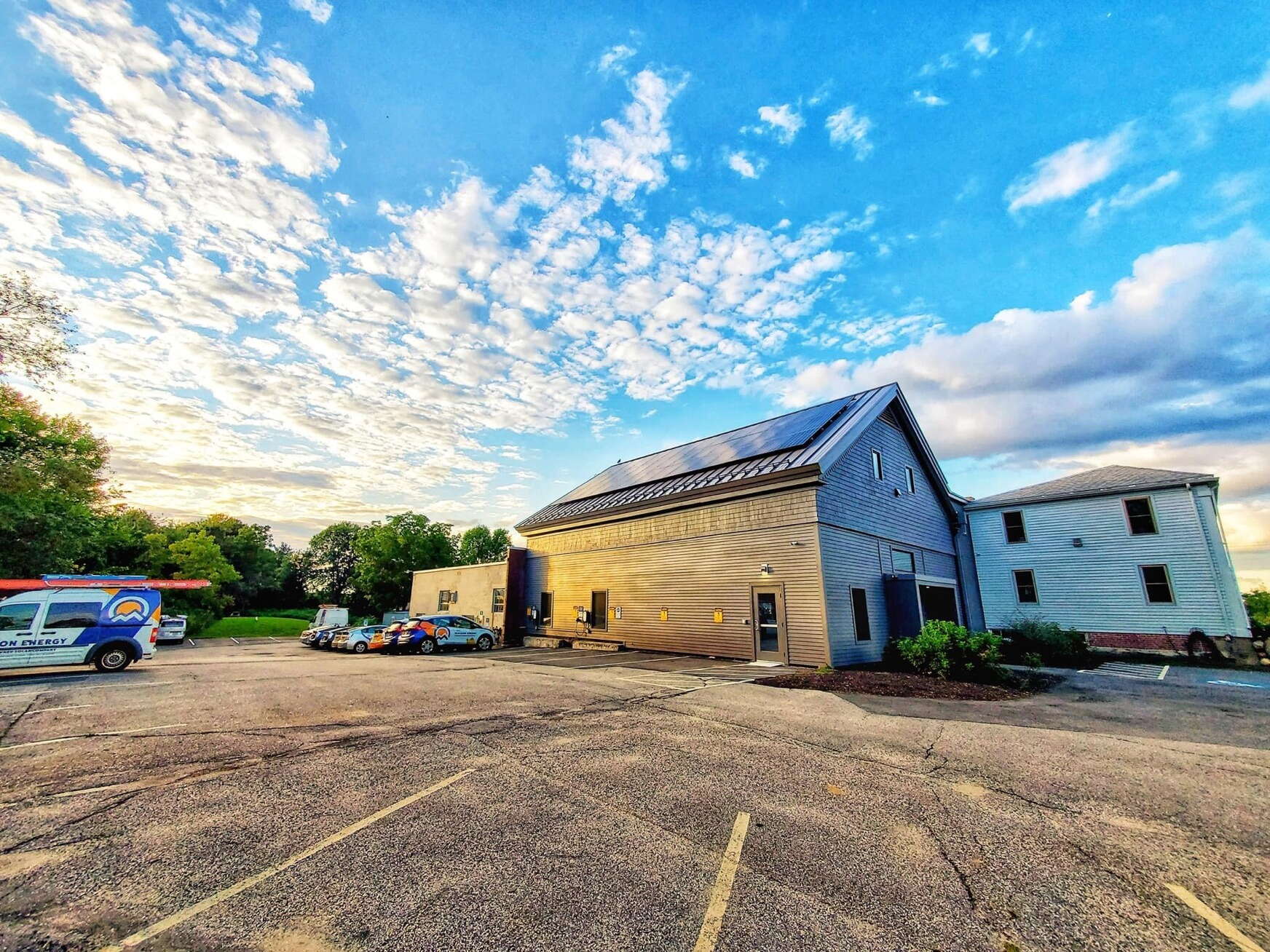wide-angle photo of building sky and parking lot