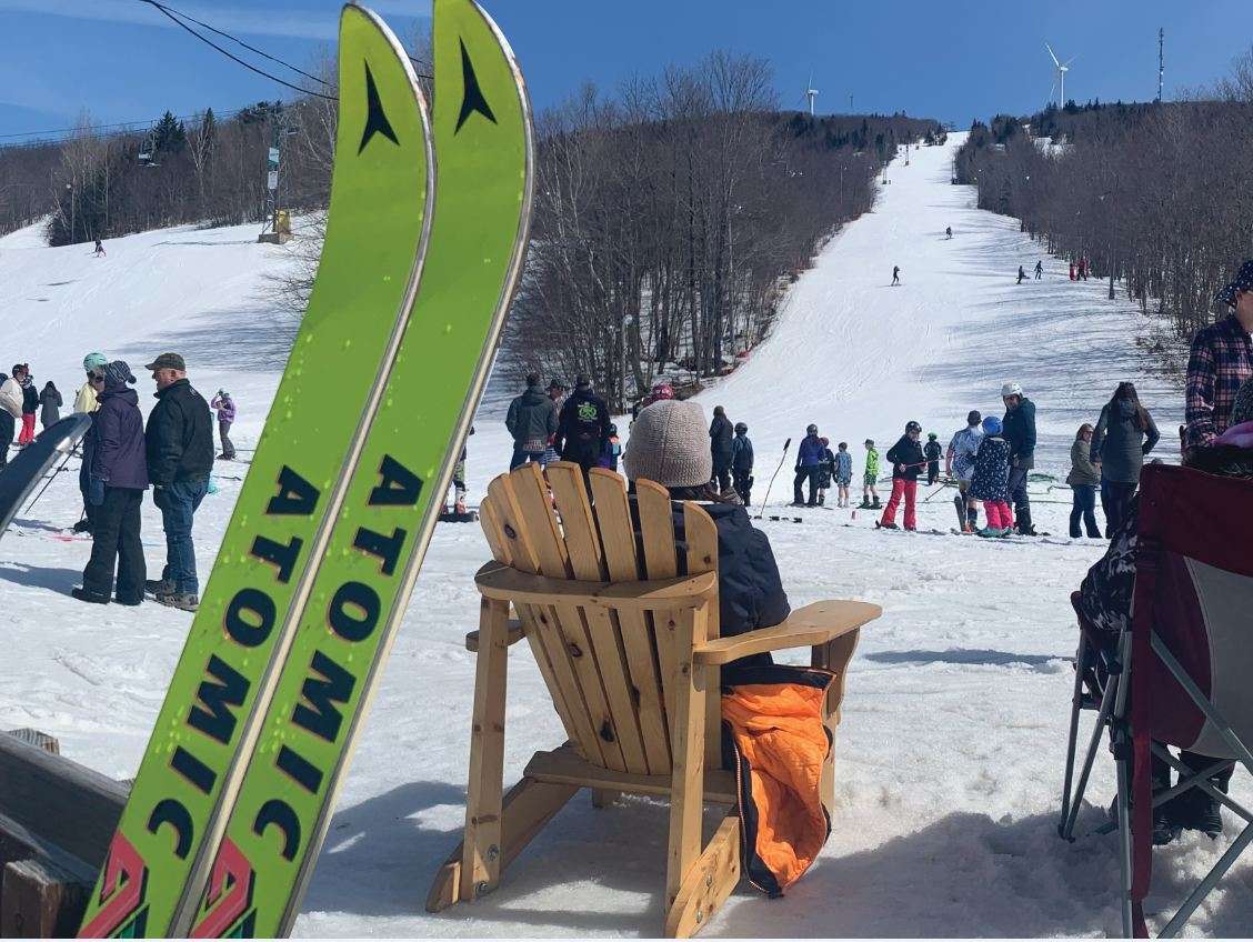 people skiing and sitting and skis sticking up