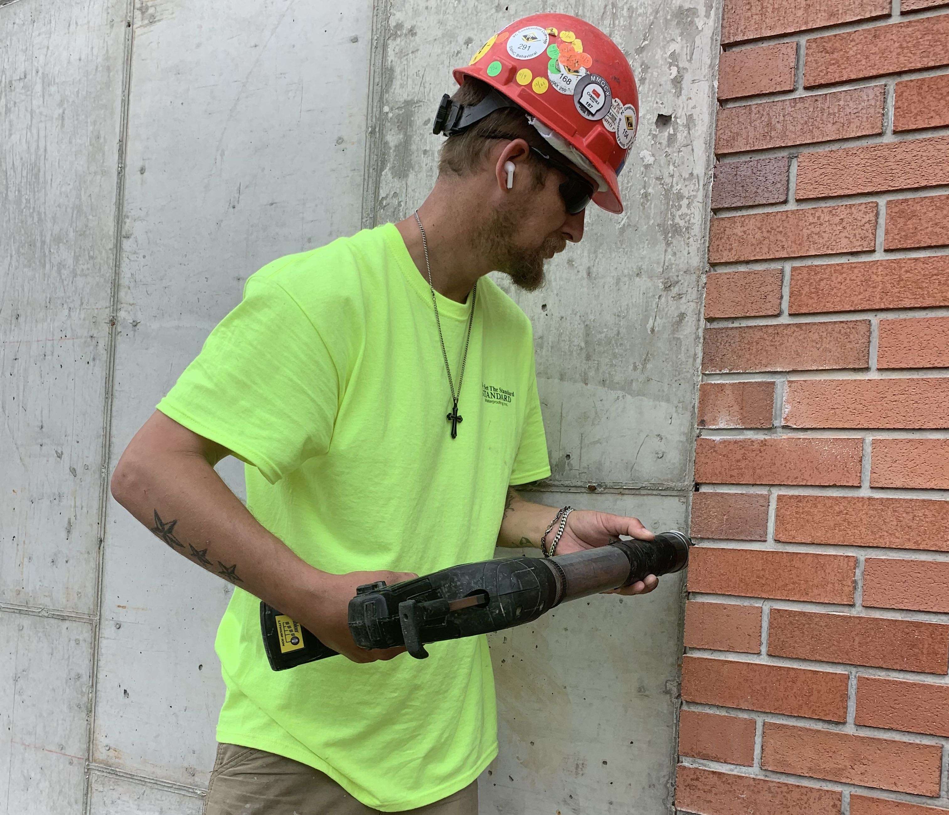 person with tool and brick wall