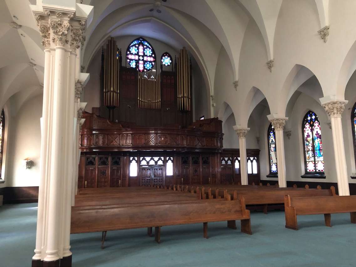 inside church with columns and stained glass windows