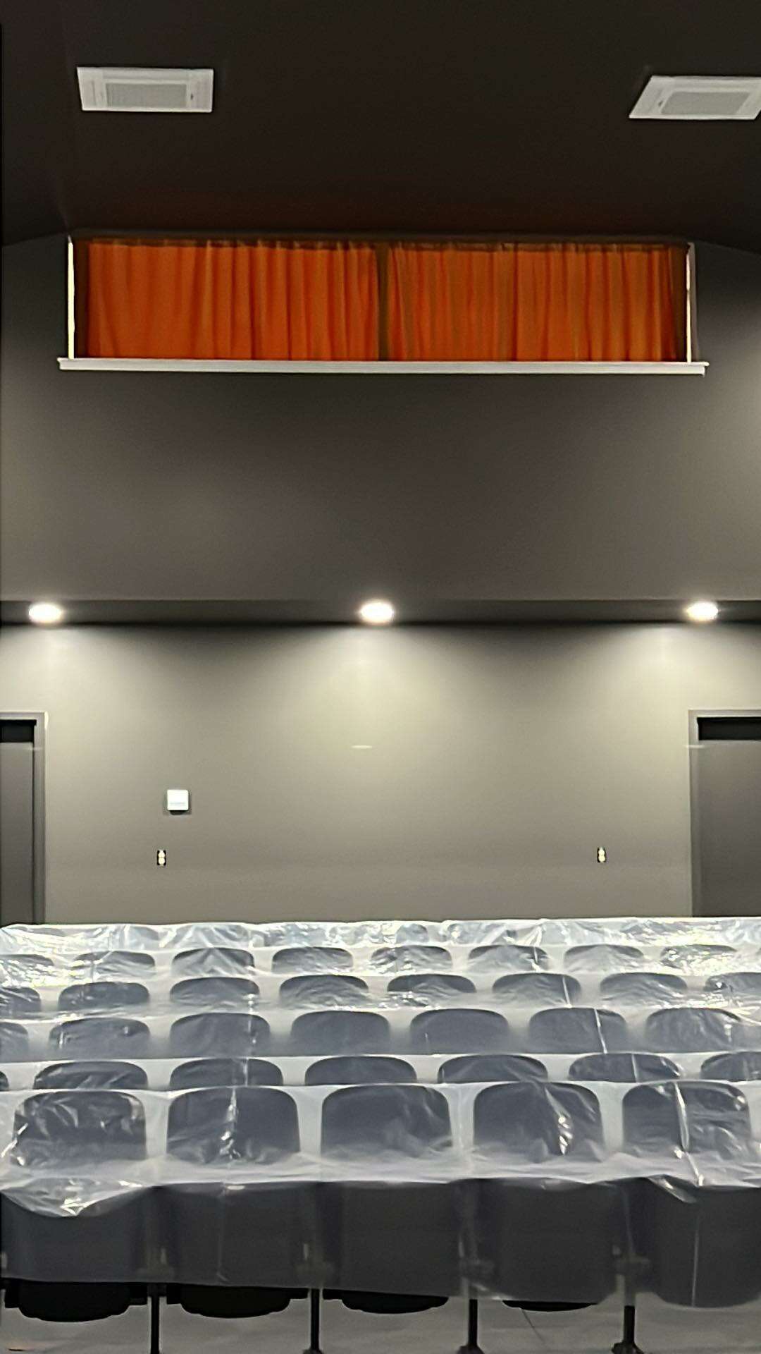 seats covered in plastic and red curtain