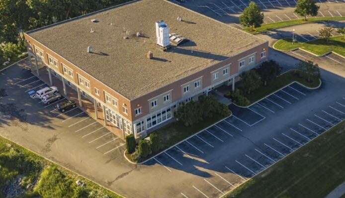 aerial of building with flat roof and parking lot