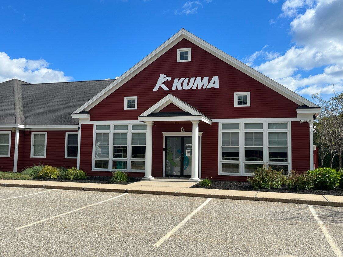 red building with white trim and parking lot