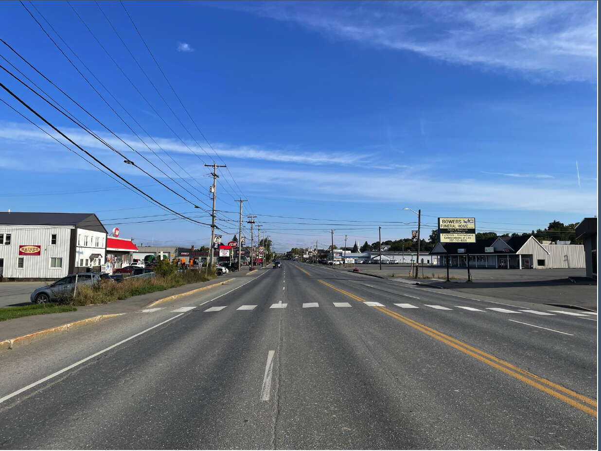 wide road with utility lines and shops