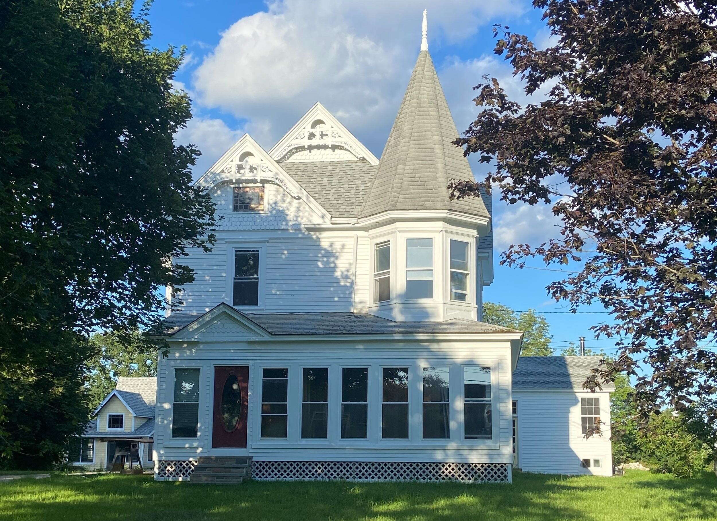 old white house with green lawn