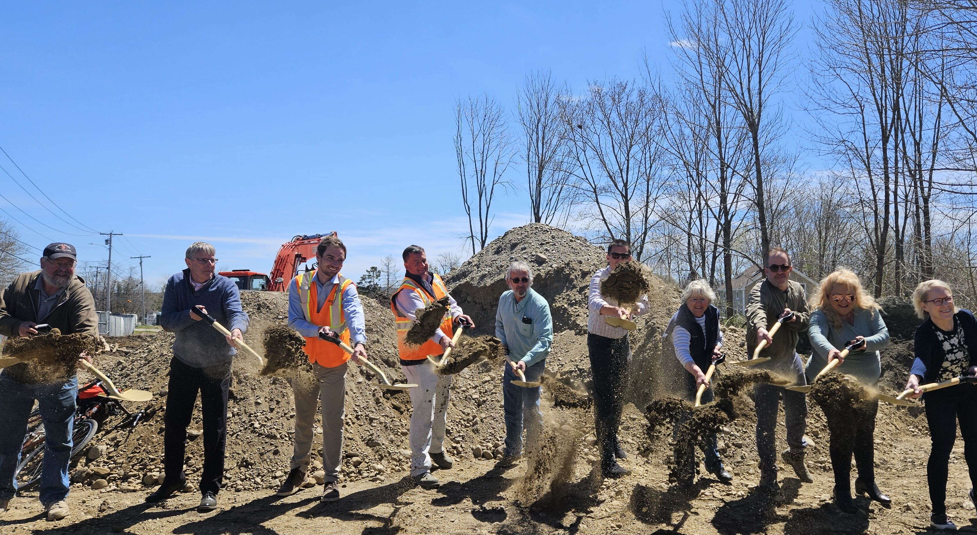 people standing in a line with shovels