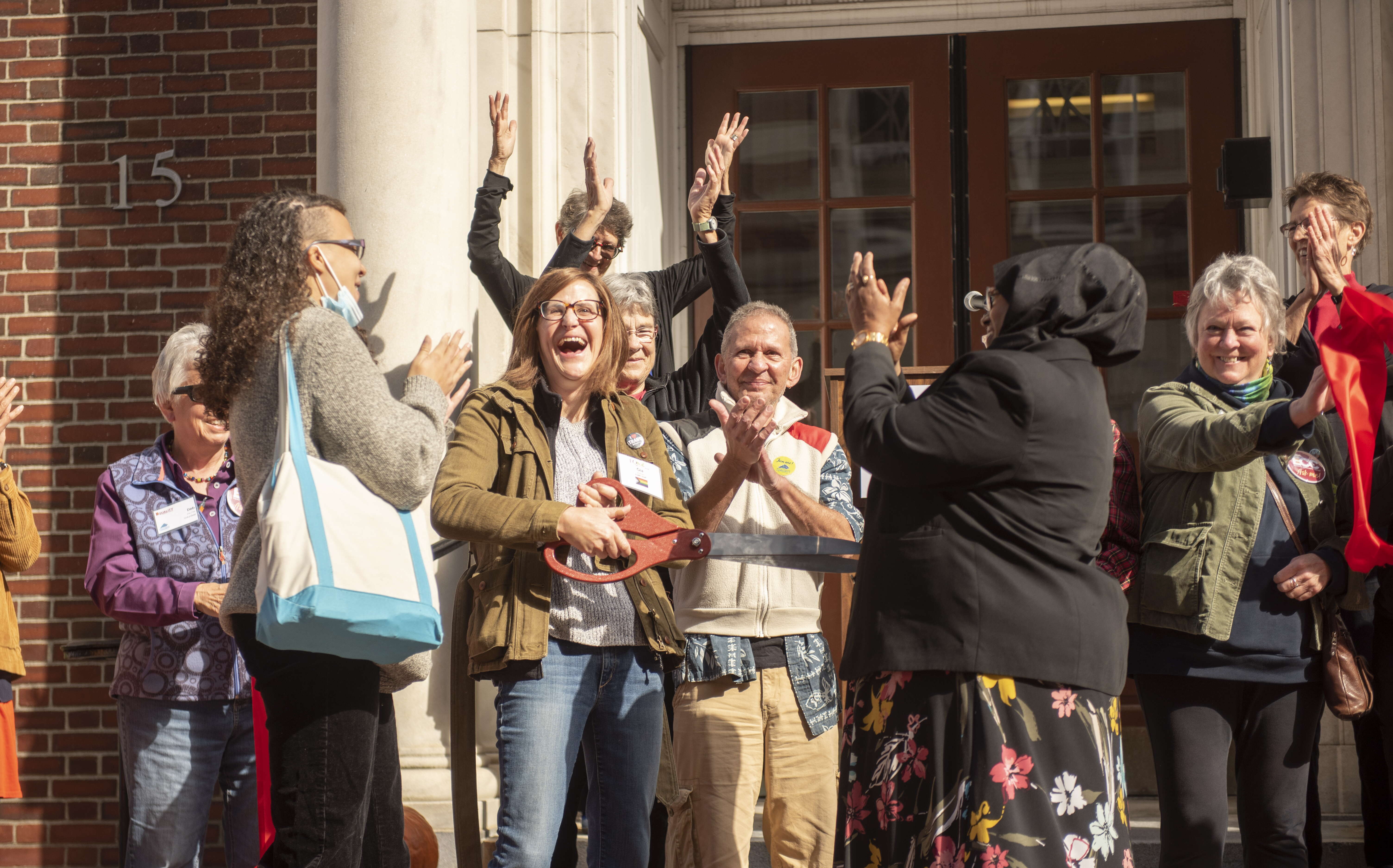 People are laughing and clapping outside the Equality Community Center's door.