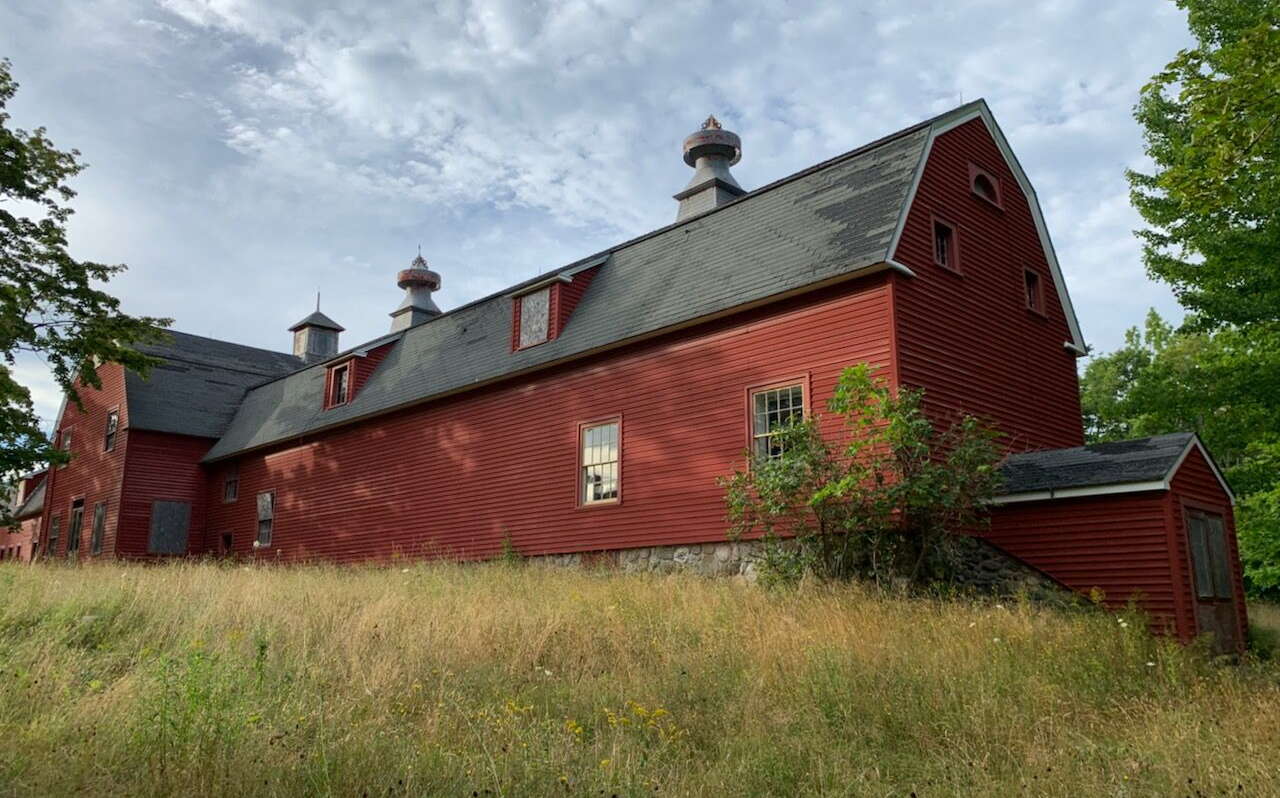 A red barn sits in a field.