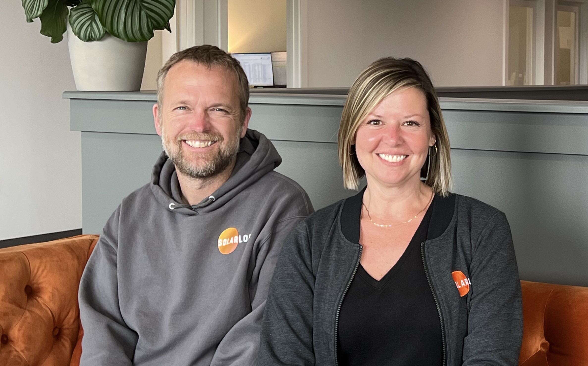 SolarLogix's leaders pose while sitting on a couch.