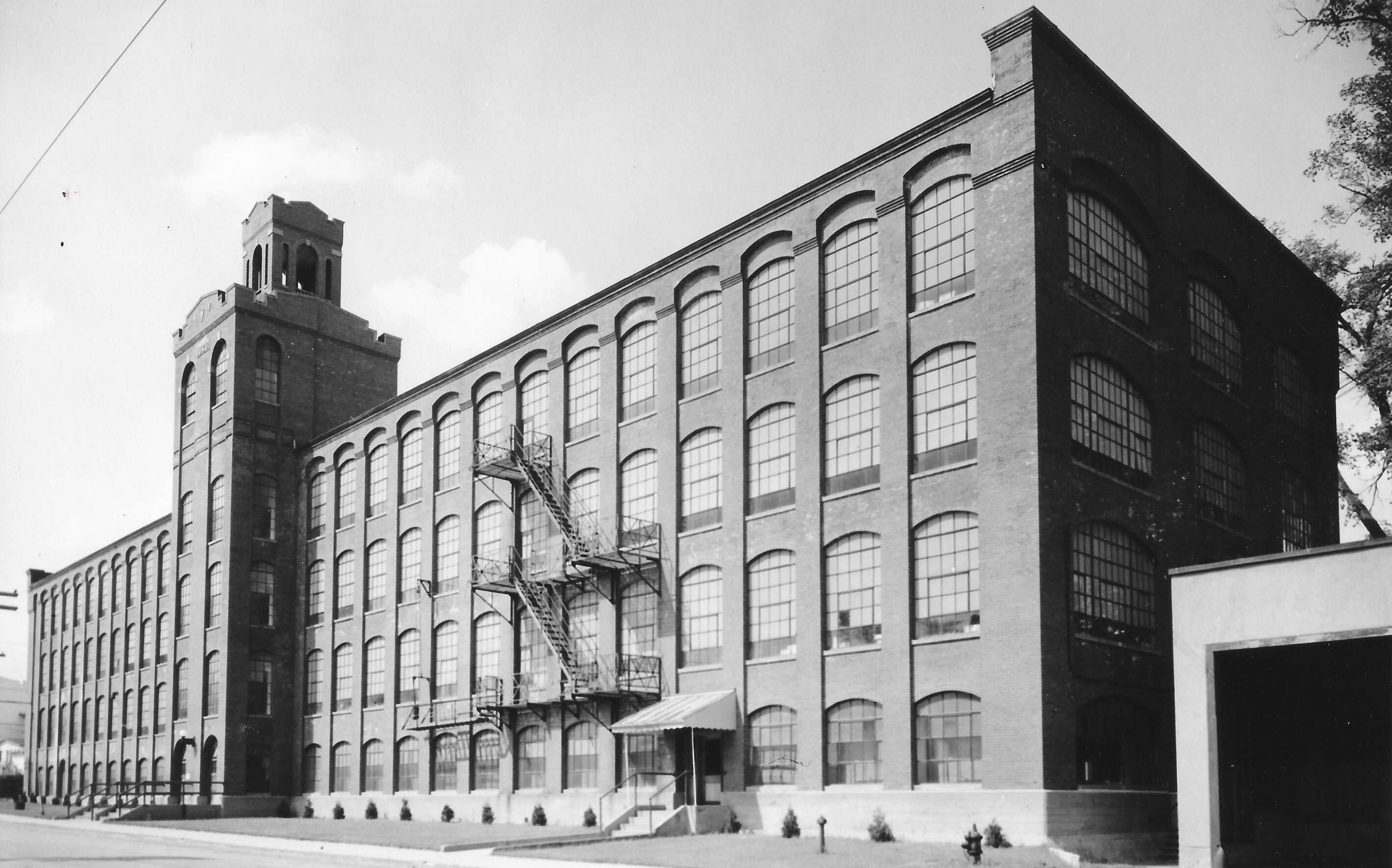 An old black-and-white photo shows a big factory building.