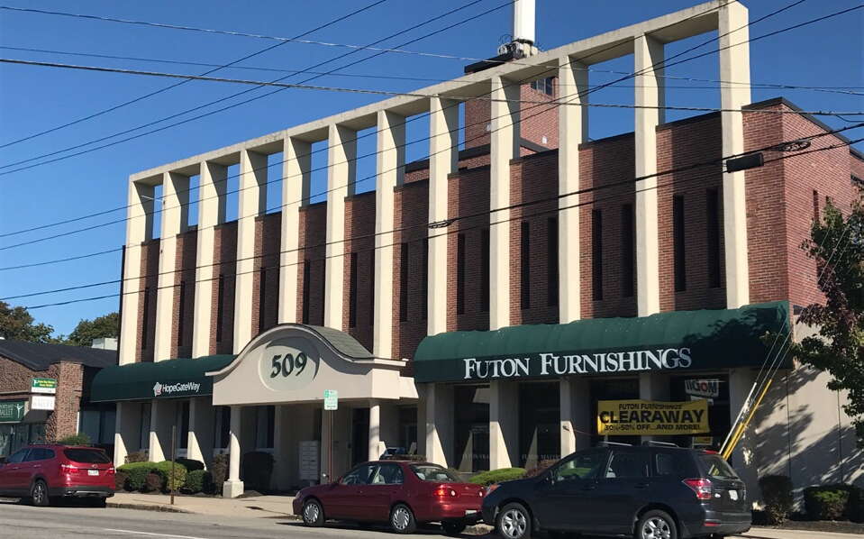 A brick building has pillars and awnings.