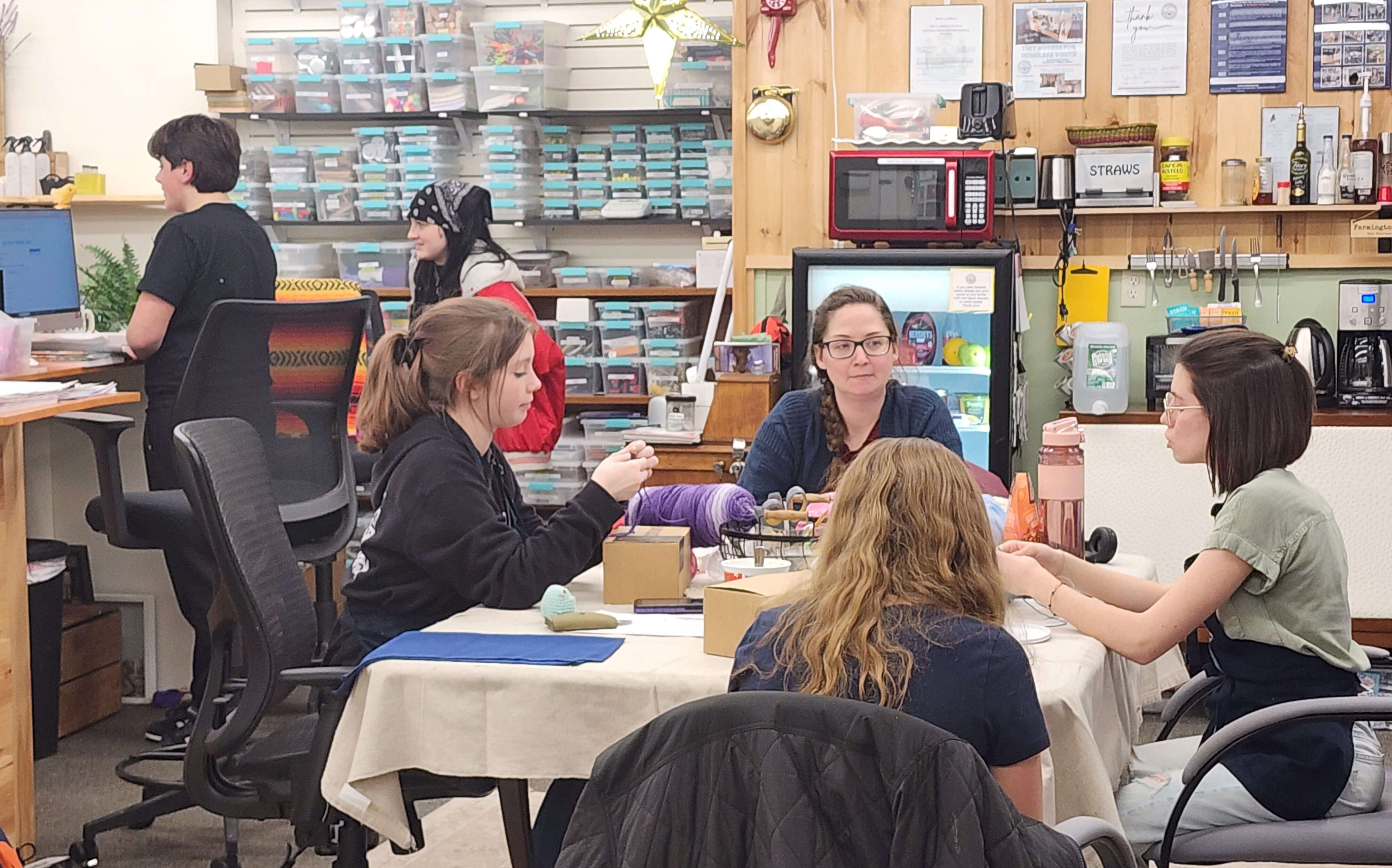 People make products at a table and a counter.