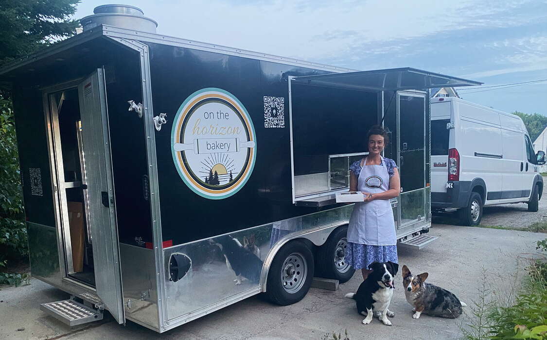 The owners stands outside of her bakery truck.