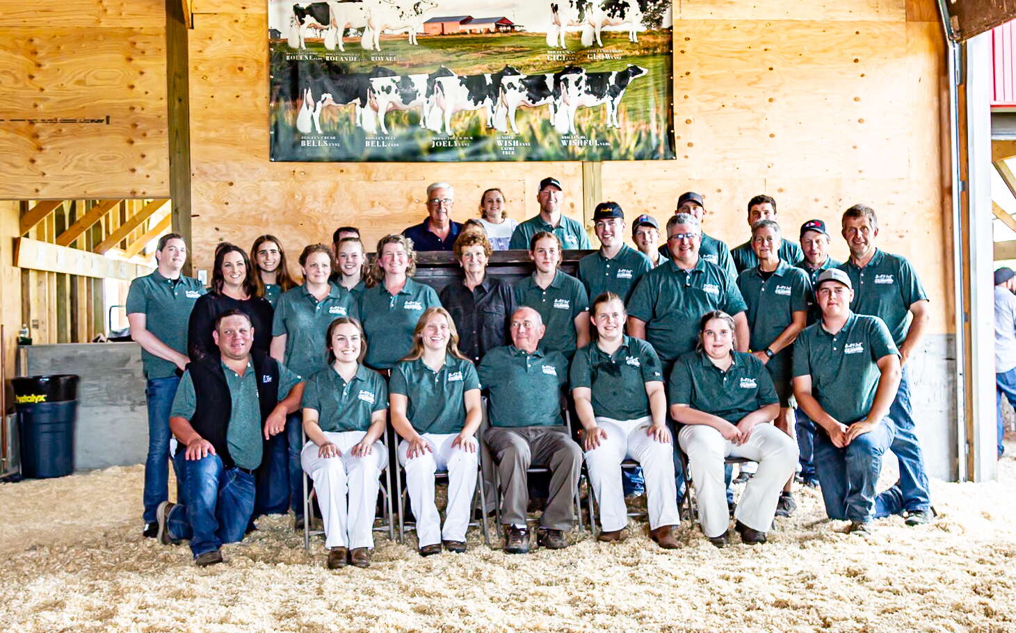 A group of people at Brigeen Farms poses in a barn.