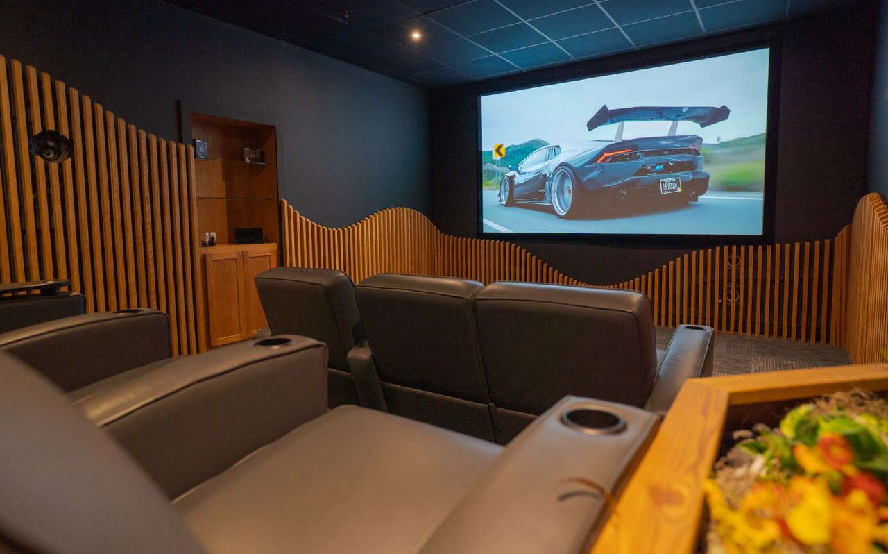 A room with a screen and seating.