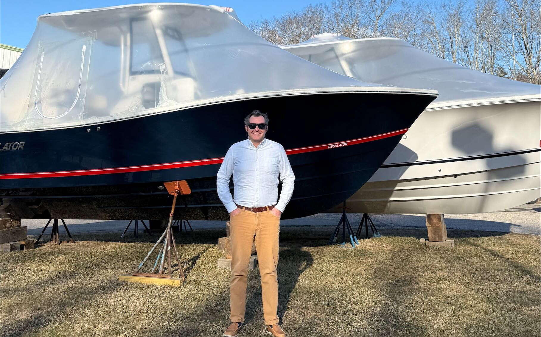 A person stands in front of a boat.