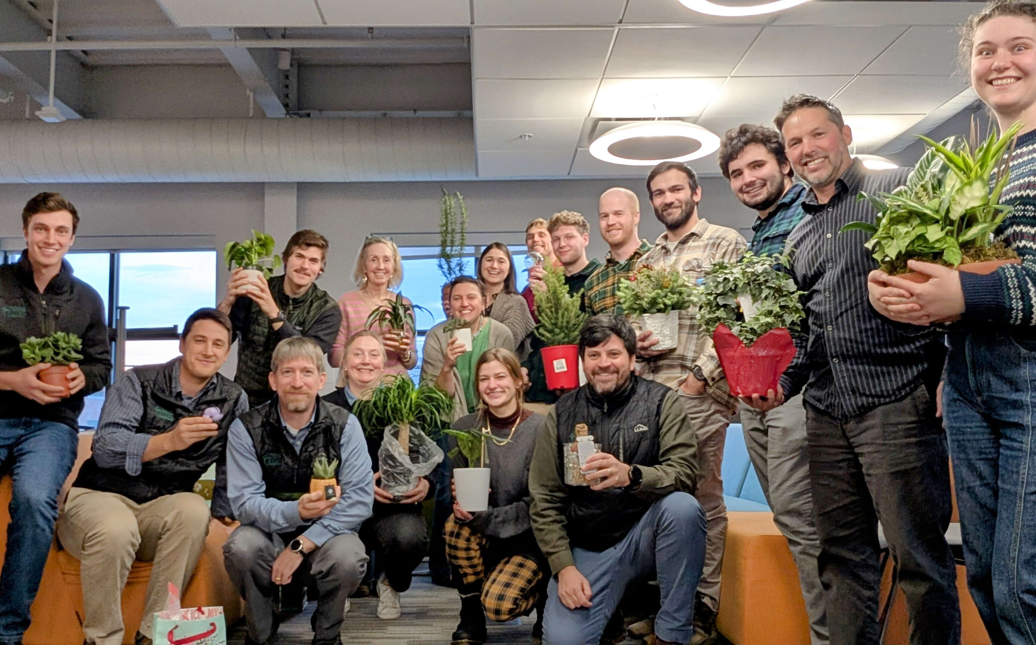 People pose with plants.