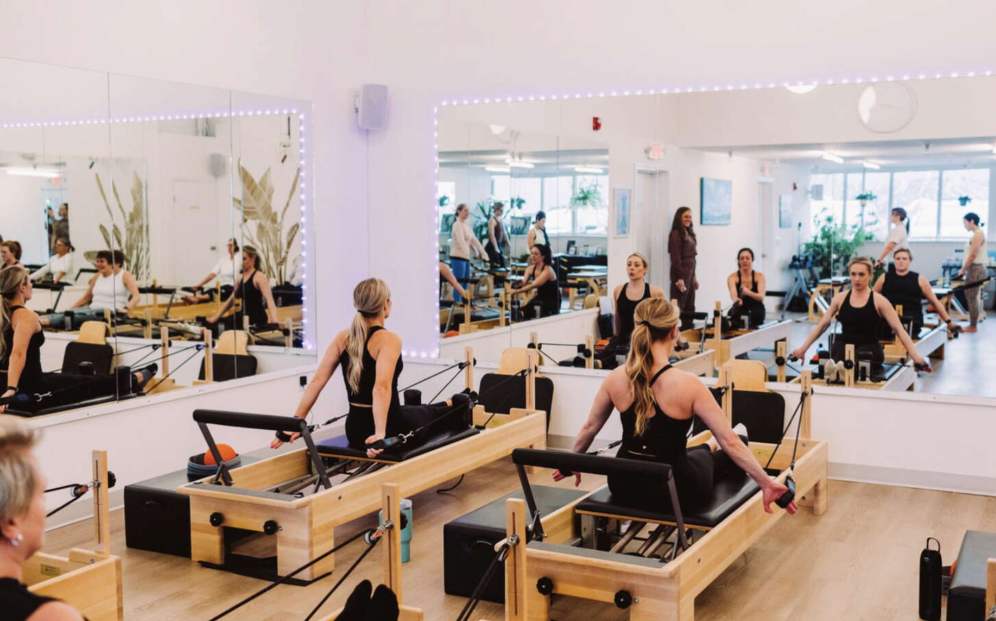 People sit on Pilates tables and look into mirros.