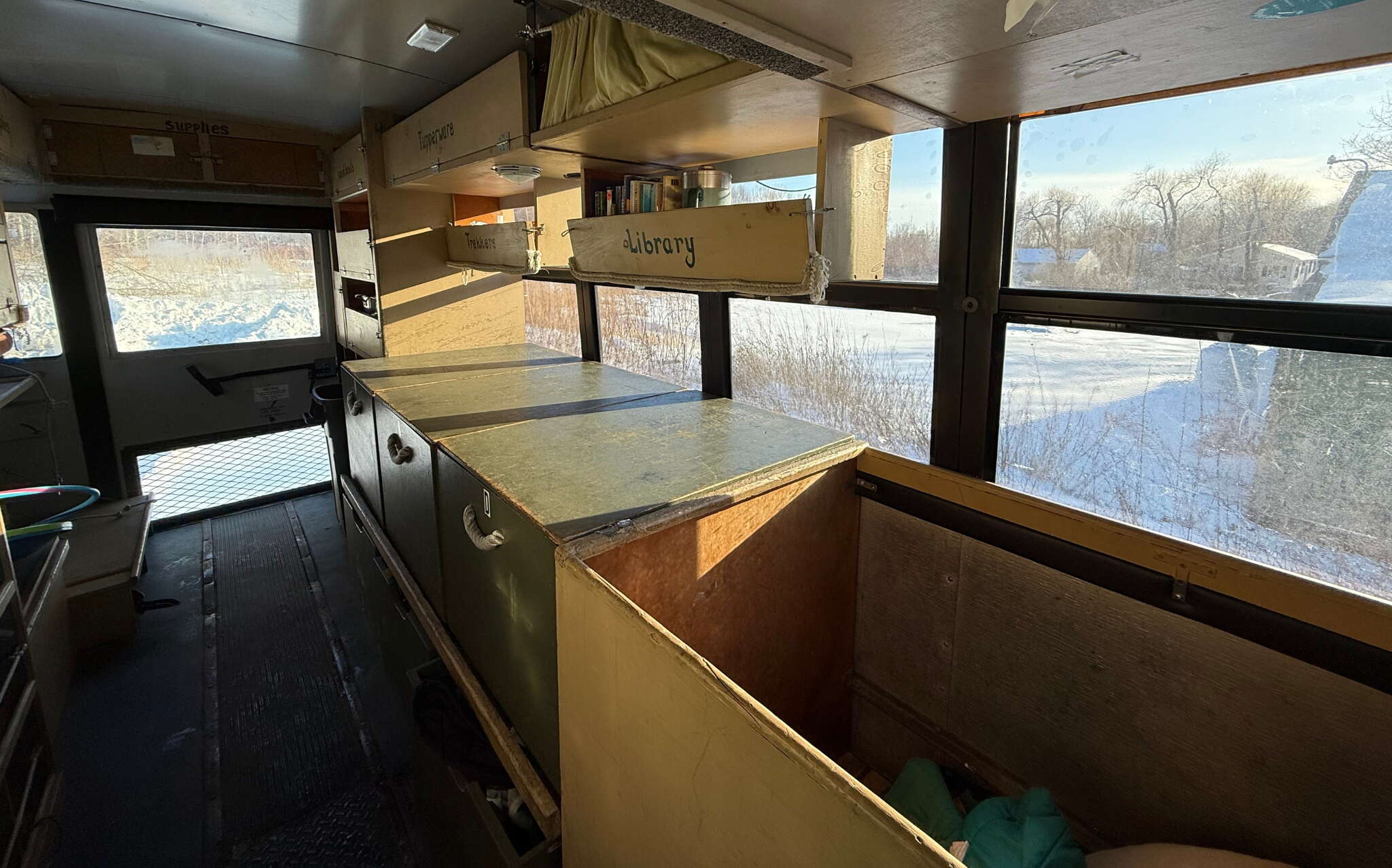 A bus interior is fitted with cabinets.