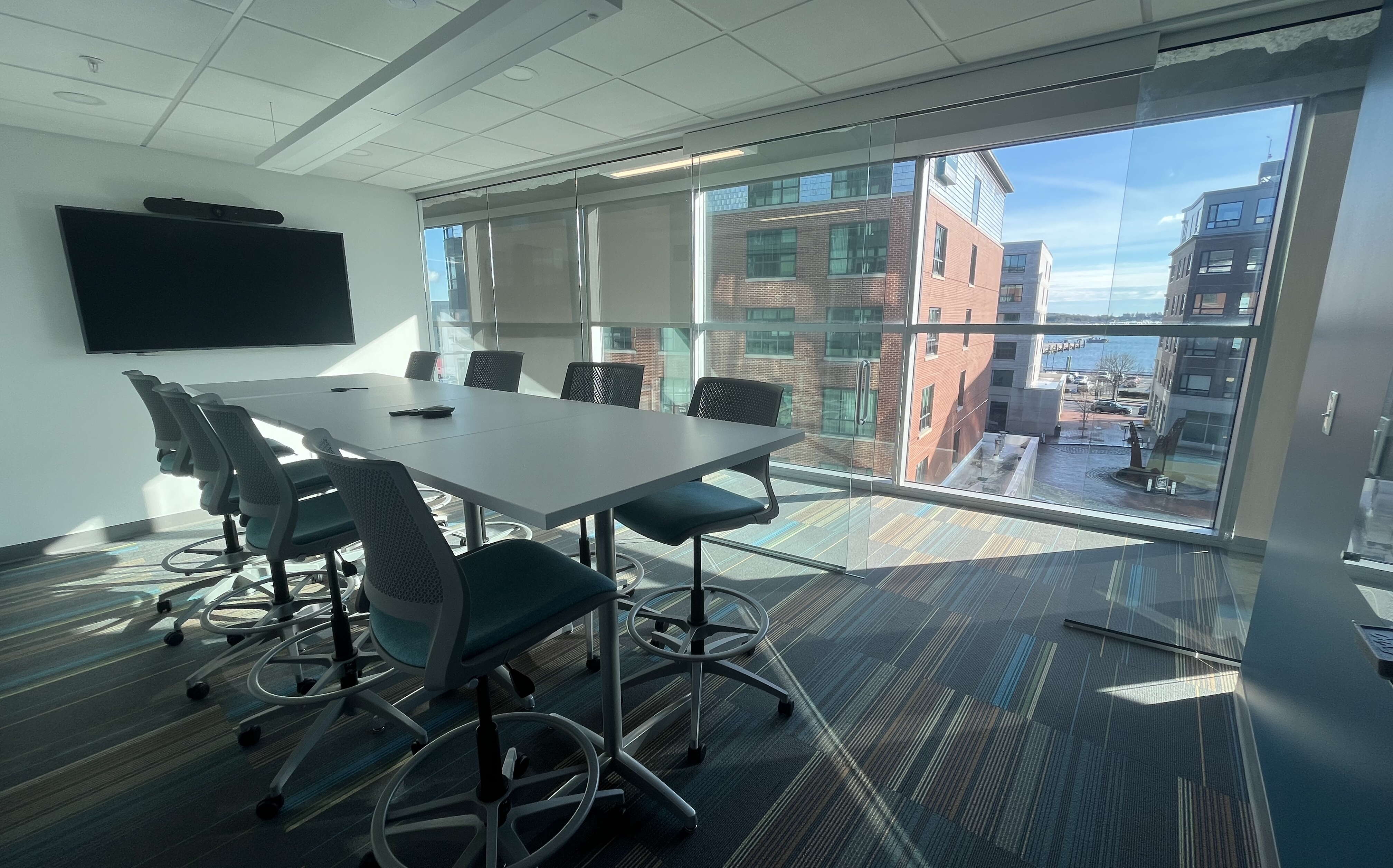 An office interior includes a table, chairs and windows.