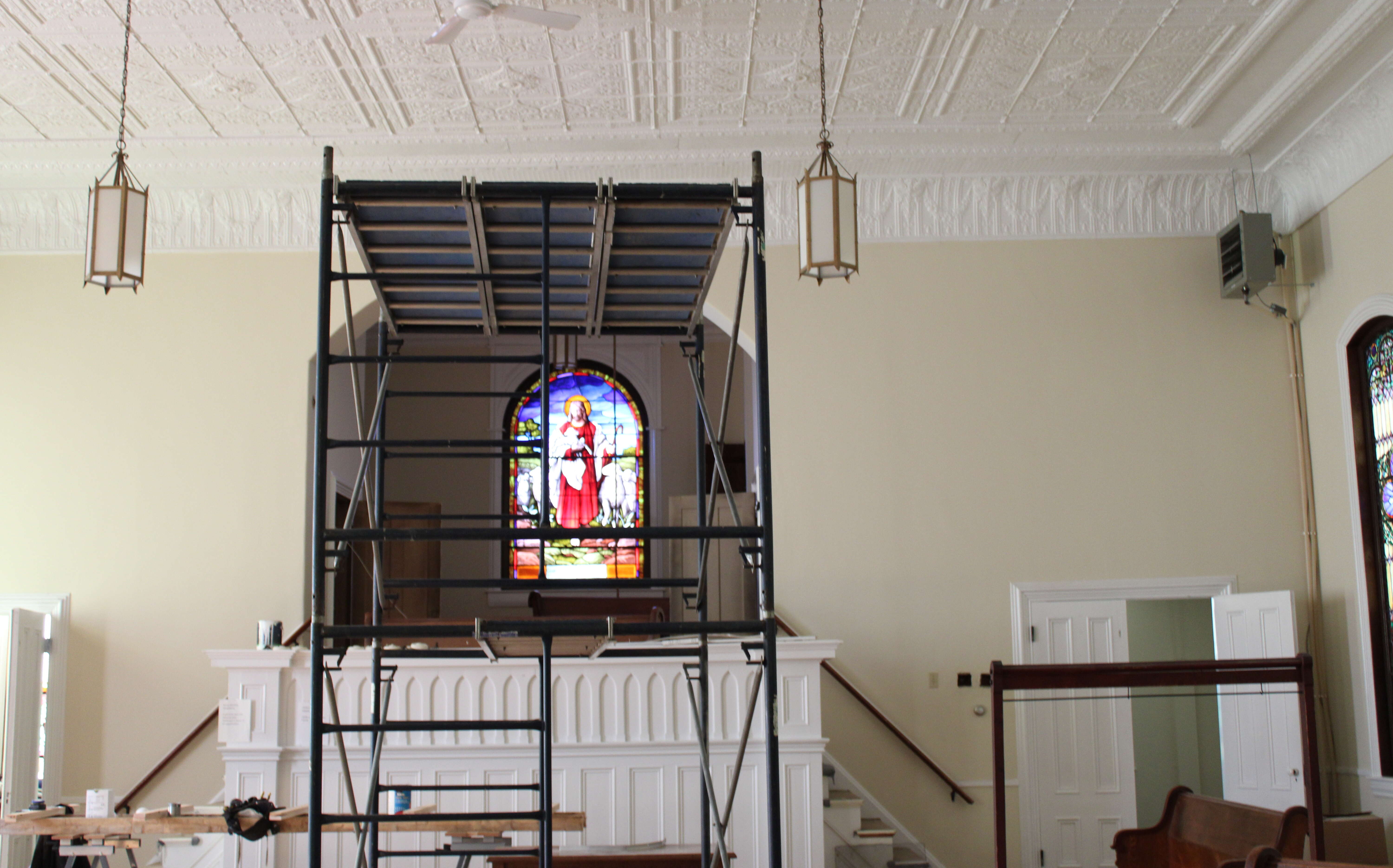 Scaffolding and a colorful windown in a big space.