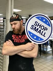 Fork Food Lab member holding up a "Shop Small" sign 