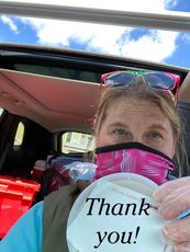 Staff member with a mask on preparing to deliver meals 