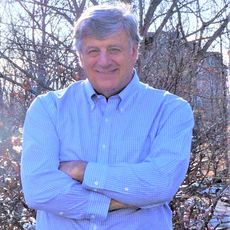 A man smiling with his arms crossed