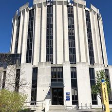 a round white cement building about seven stories high