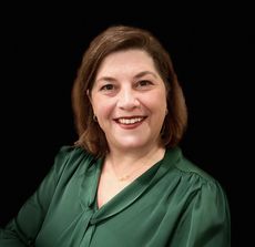 Portrait photo of Rebeccah Sanders wearing a green blouse.