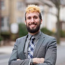 smiling person in jacket and tie