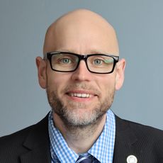 person with checked shirt, tie, glasses