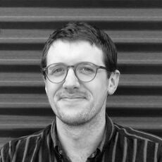 black and white photo of person in glasses and striped shirt