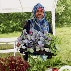 A farmer shows some of her crops.