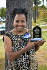 A person poses with an award.