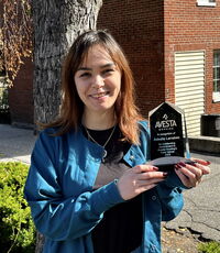 A person poses with an award.