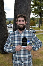 A person poses with an award.