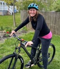 Laragh is on a bike in a yard.