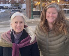 Two people stand on a downtown street.