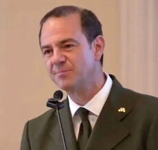 A person stands at a microphone.