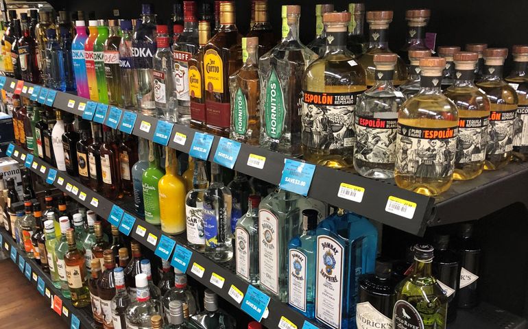 A store shelf with a variety of bottles of alcohol