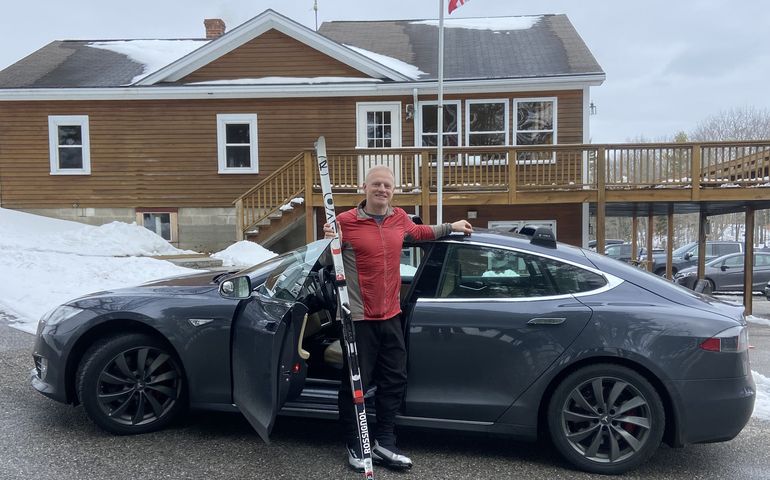 Martin Grohman with his electric car, a Tesla, and Nordic skis.