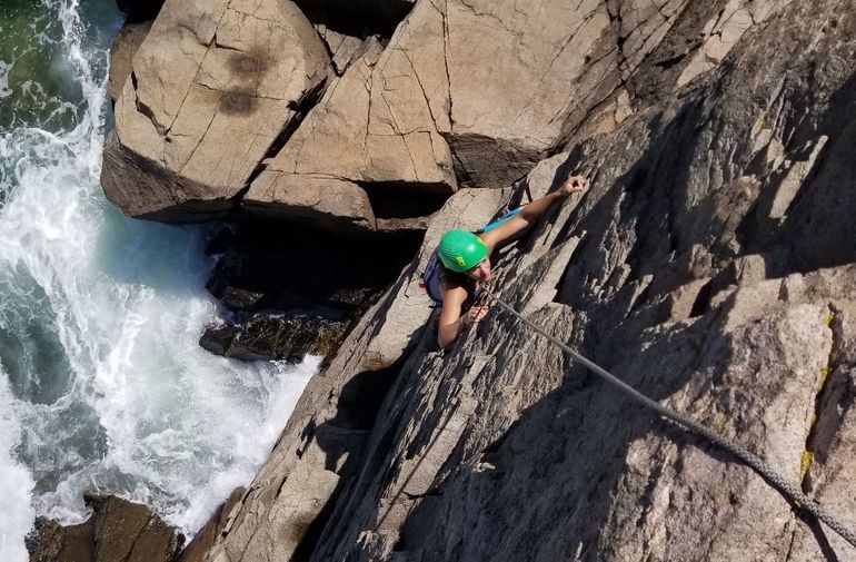 person in helmet on rock wall