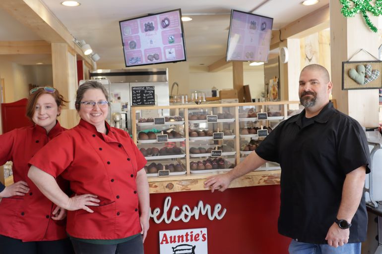 3 people at counter with chocolate display