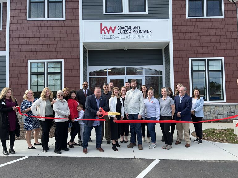 group of people with ribbon at building entryway