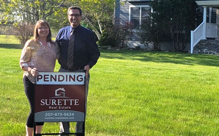 2 people with sign on lawn