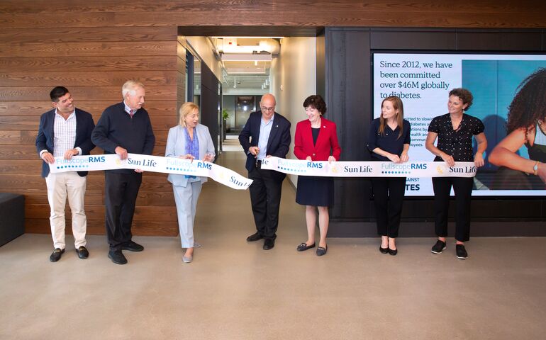 People cutting ribbon at building opening