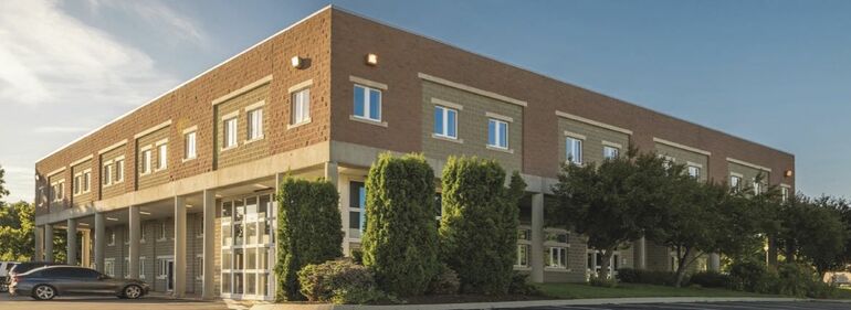 building with border of trees and  bushes