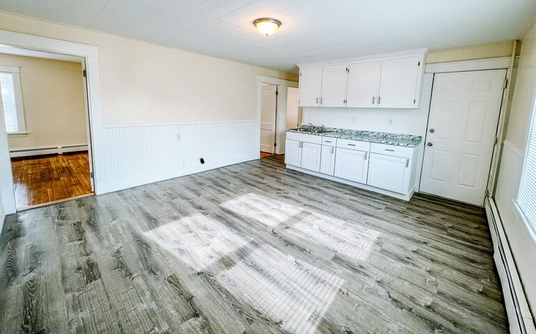 empty apartment room with kitchen and living room