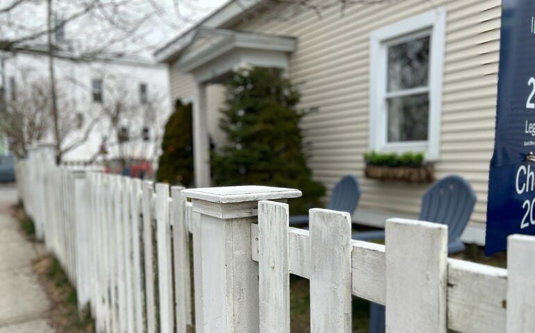 Oblique view of house with picket fence.